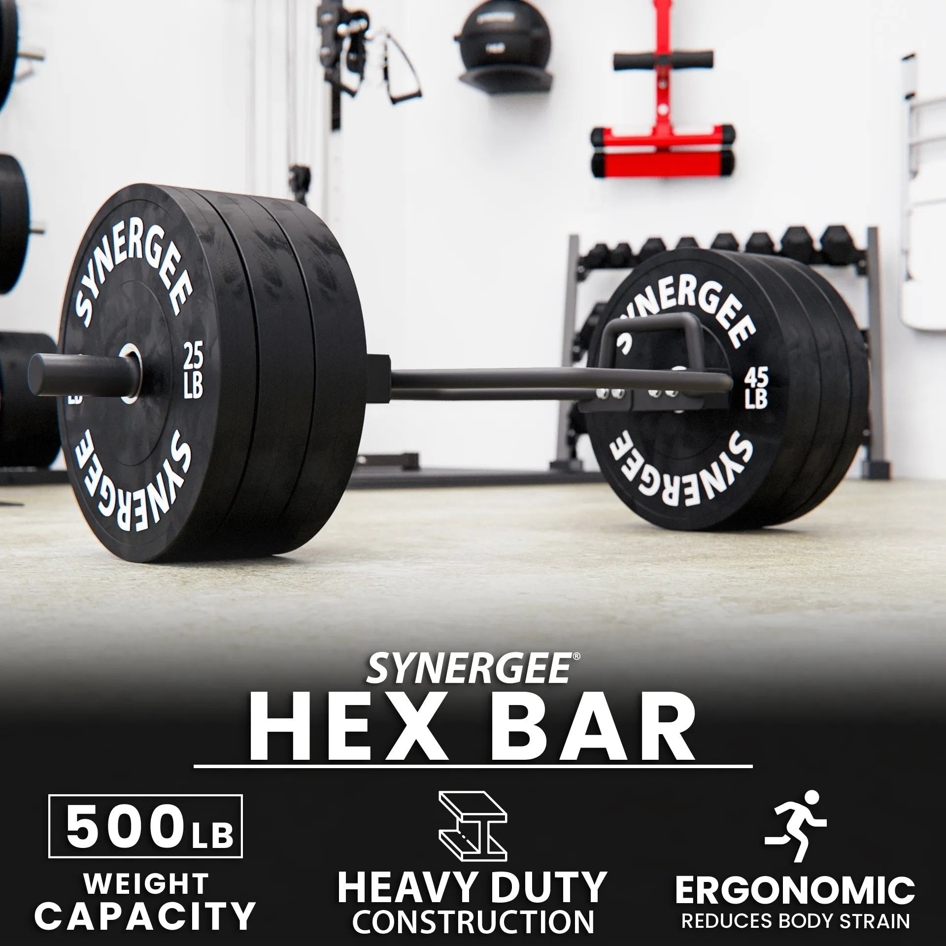 Synergee hex bar loaded with black weight plates labeled 25 LB and 45 LB on a gray gym floor, with wall-mounted equipment and dumbbell rack visible in the background.