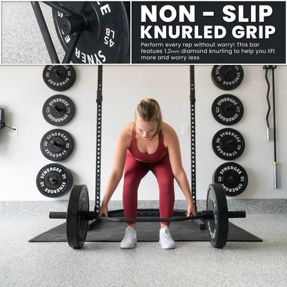 Woman performing a deadlift with a black hex trap bar loaded with weight plates in a gym. Close-up detail shows the knurled grip texture of the bar.