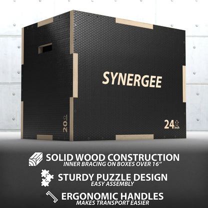 Black hexagonal-textured plyo box with light wood trim and handles, labeled "SYNERGEE" and "24 inch," displayed against a white metal wall background.