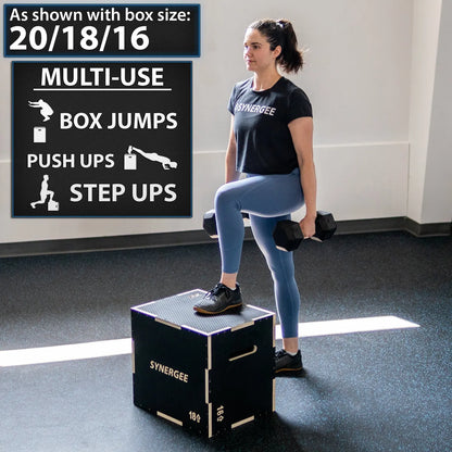 Woman performing a step-up on a black wooden plyo box with textured top surface and gold trim, holding dumbbells in a gym setting.