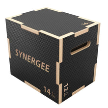 Synergee wooden plyo box with black rubber-textured top surface, natural wood edges, and side handles. Box labeled "14 inch" with textured rubber coating on all sides for non-slip grip.