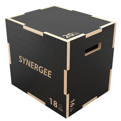 Black plyo box with textured rubber top surface and natural wood trim, marked with 20-inch and 18-inch height indicators on the sides. The box features "SYNERGEE" branding and grip handles for carrying.