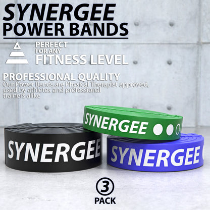 Three Synergee resistance power bands in black, green, and blue, coiled and displayed on a white concrete background.