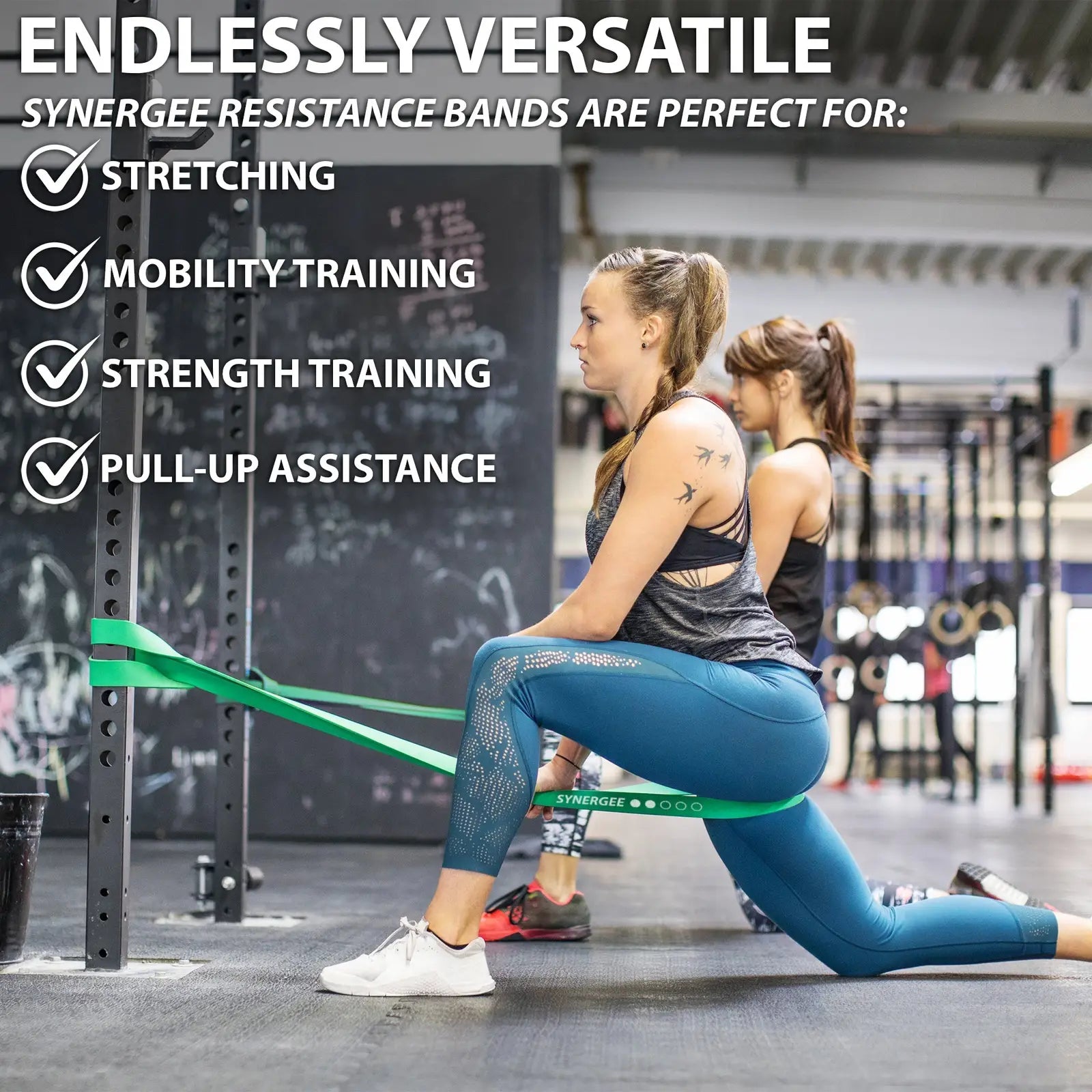 Woman performing a lateral lunge with a green resistance band looped around a pull-up bar in a CrossFit gym setting.