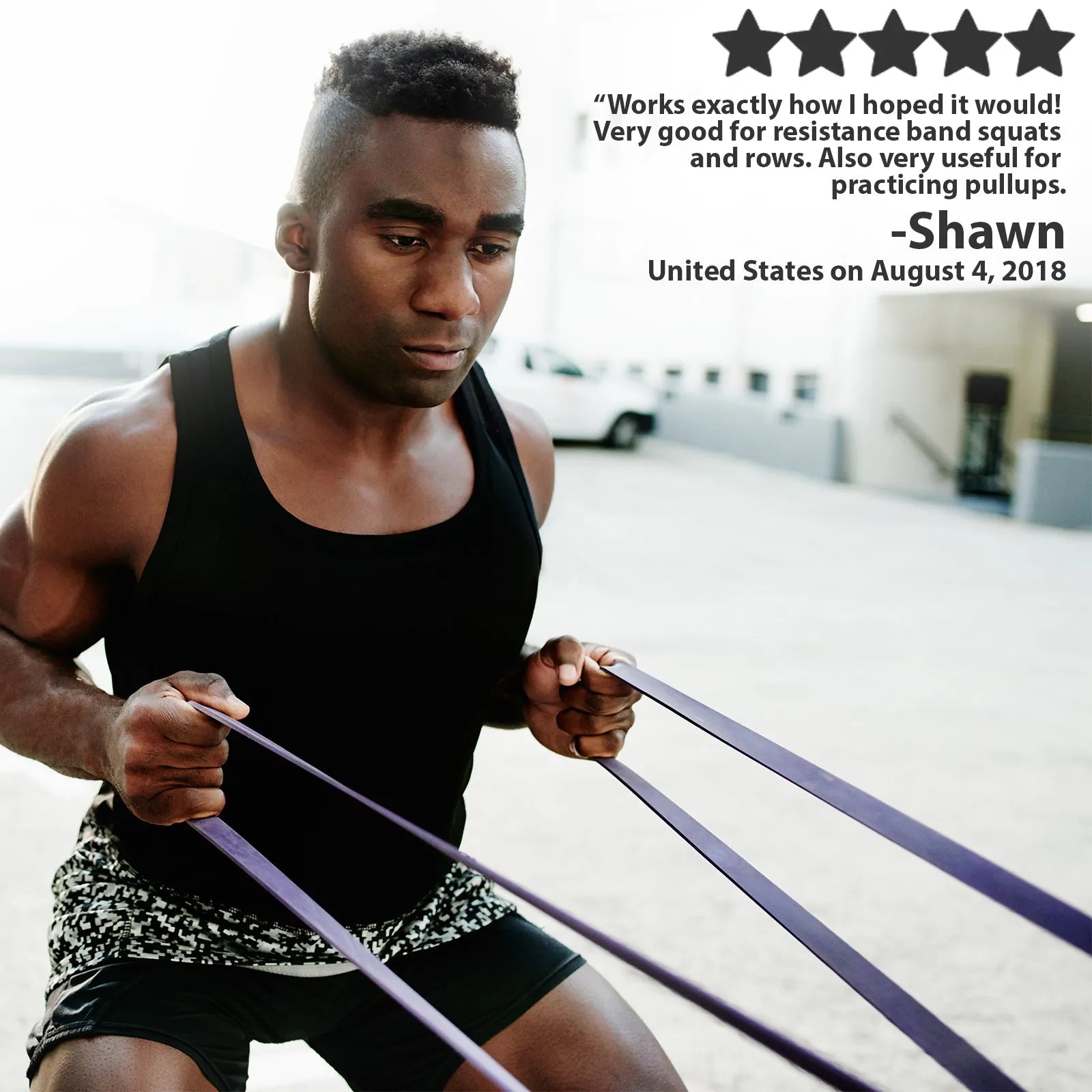 Man performing a resistance band exercise outdoors, holding a purple loop resistance band in both hands while in a squatting position.