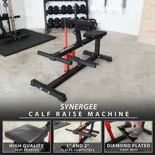 Black and red seated calf raise machine with padded seat, foot rest, and barbell holder in a gym setting. Machine is compatible with 1" and 2" weight plates.