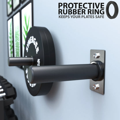 Black rubber ring mounted on a metal wall bracket with bolt anchors, positioned next to a barbell loaded with weight plates in a gym setting.
