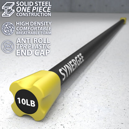Black solid steel bar with yellow TPR plastic end cap labeled 10LB, displayed on a concrete surface. The bar features a textured foam grip and anti-roll design.