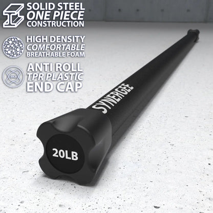 Black 20lb weighted workout bar with solid steel construction and black foam grip, displayed on speckled gray floor with TPR plastic end cap visible.