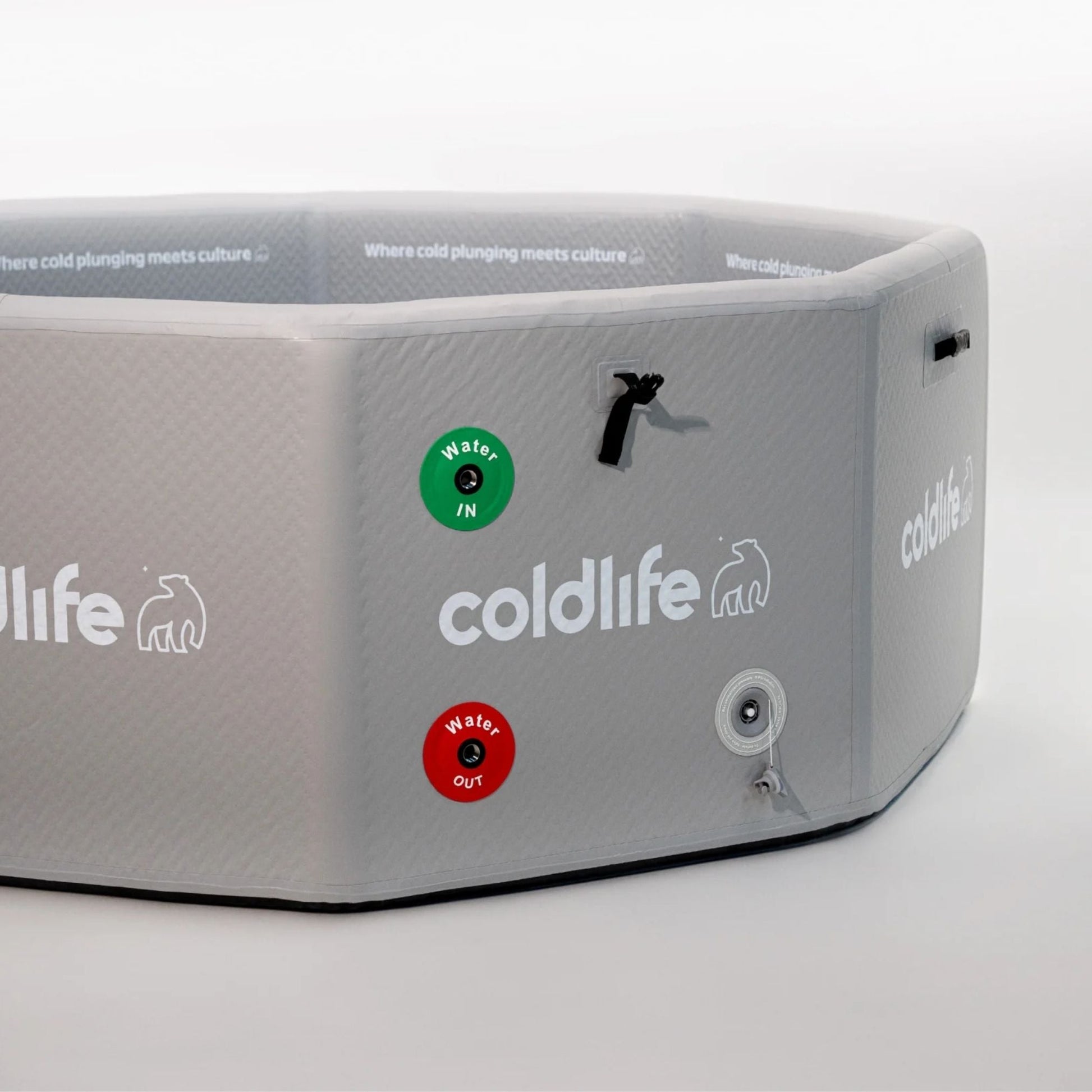 A gray octagonal cold plunge tub with the brand name coldlife displayed prominently. The tub features green and red indicators labeled Water IN and Water OUT, along with a textured surface and a drainage valve. The background is plain, emphasizing the tub's design.